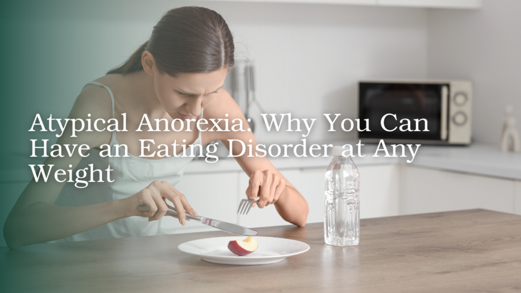 Woman sitting at a table with a small portion of food, illustrating restrictive eating and atypical anorexia